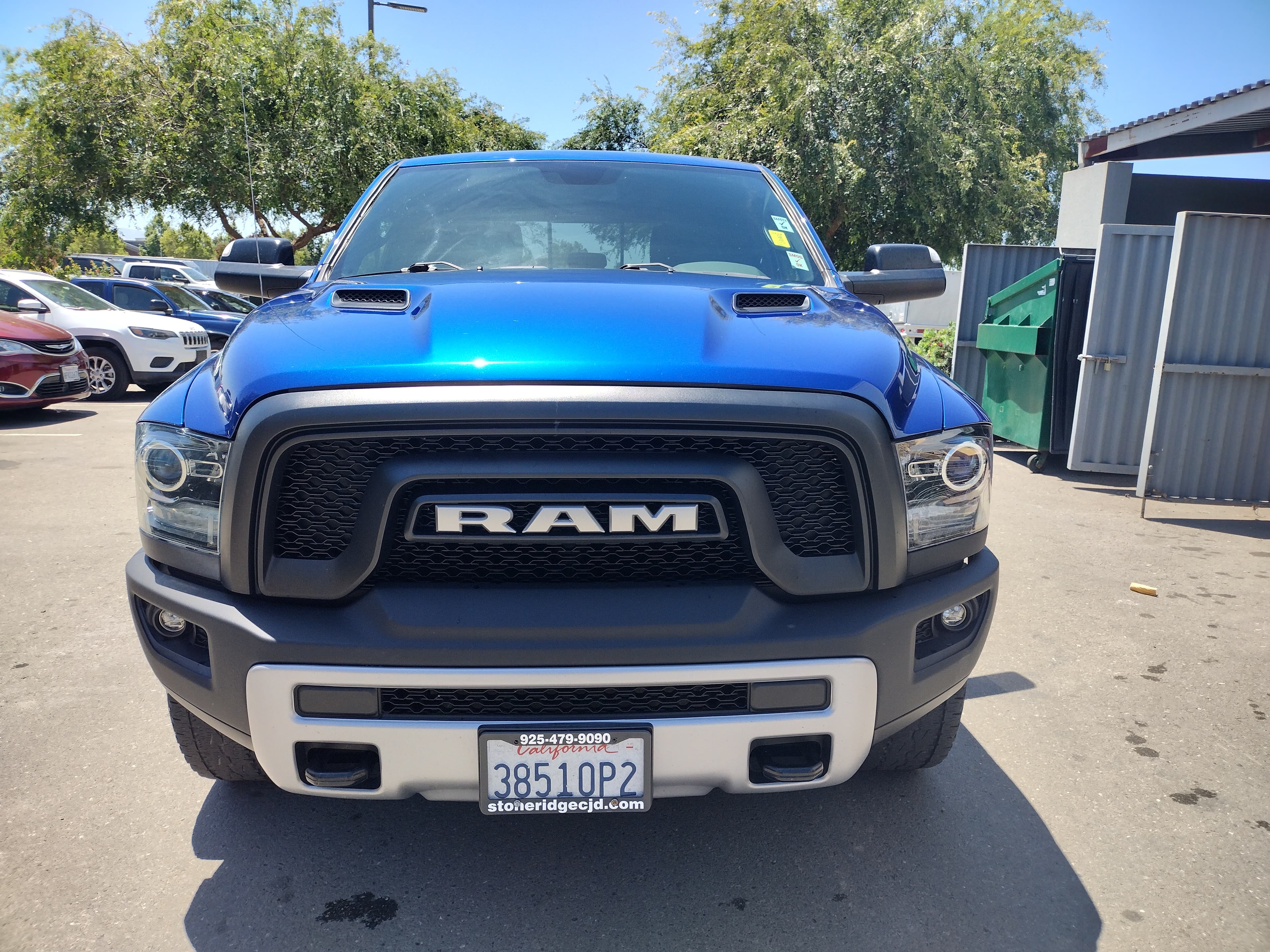 Bright blue RAM pickup truck featuring a large black grille and silver lower bumper.