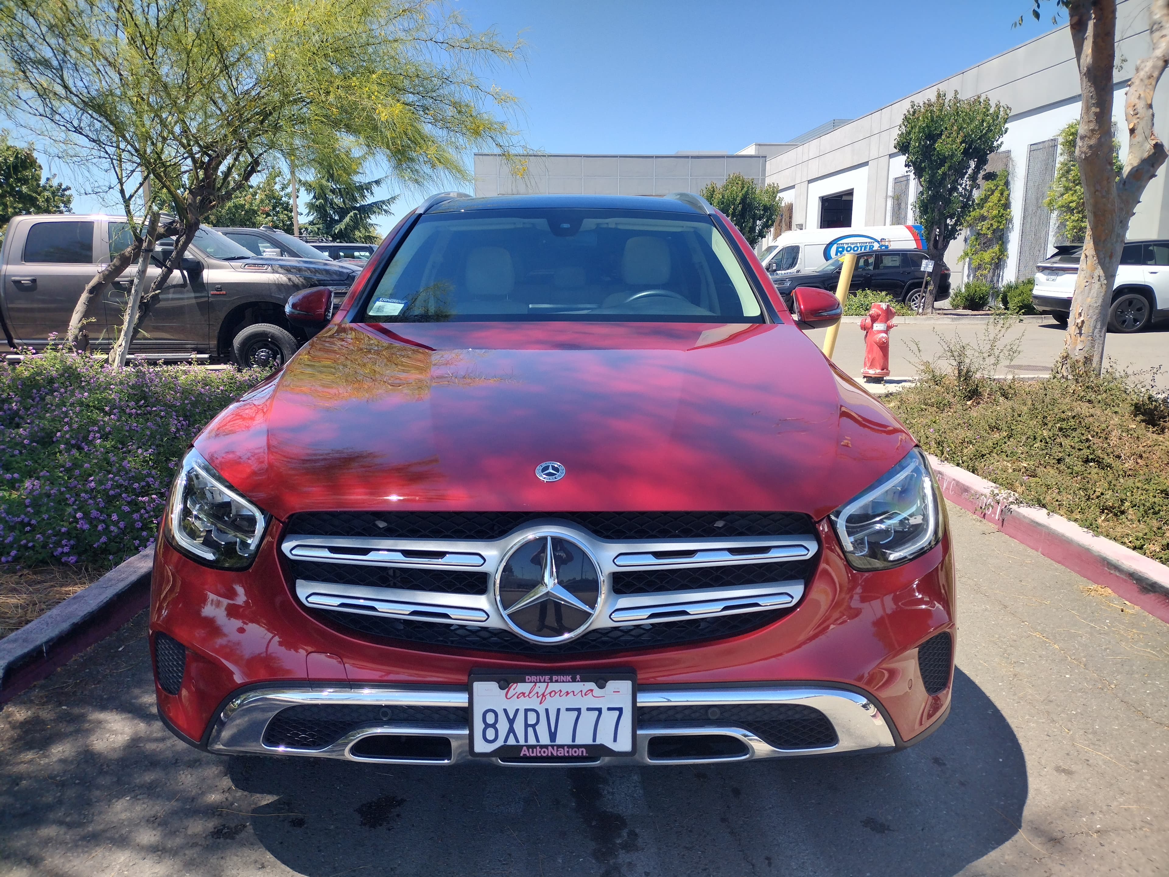 Red Mercedes-Benz SUV parked in a sunny lot with a California license plate visible.